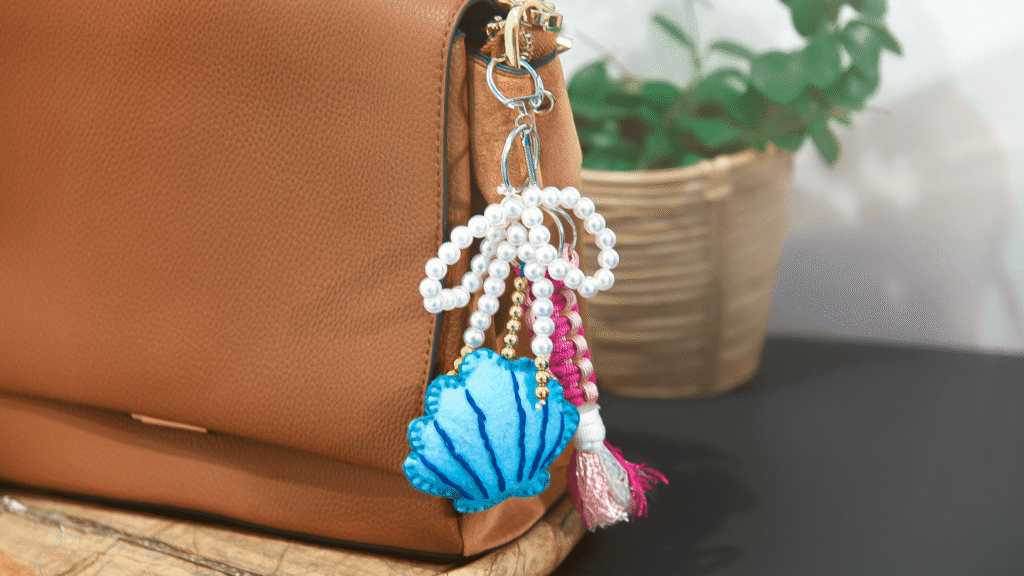 Bag Charm mit Muschel, Schleife und Knüpfanhänger
